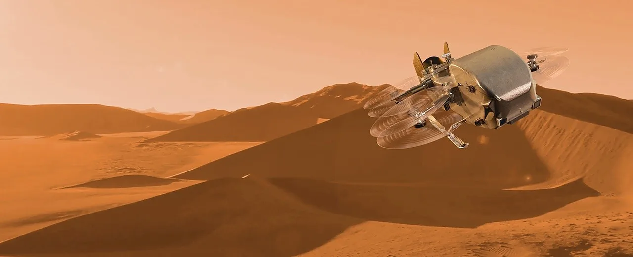 Artist's concept of NASA's Dragonfly rotorcraft, an eight-rotor drone, in flight over the dune fields of Saturn's moon Titan under an orange hazy sky.