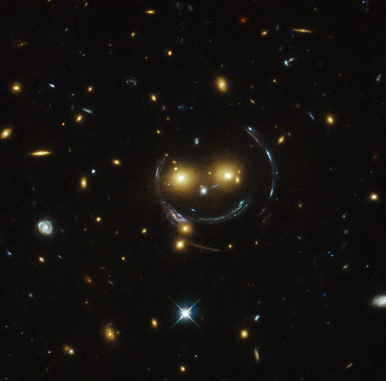 A Hubble image showing a distant galaxy stretched into a bright, near-perfect ring of light around a foreground galaxy, an Einstein ring.
