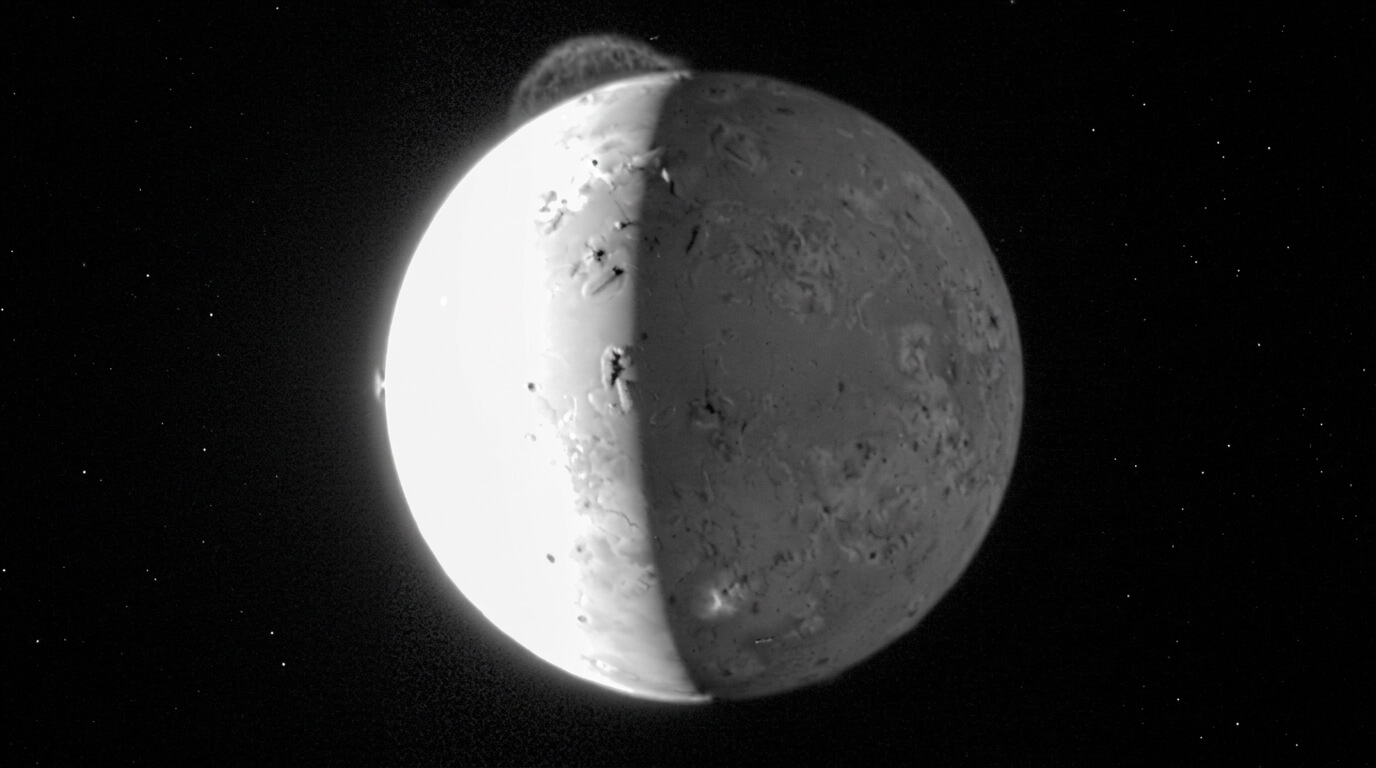 Image of Jupiter's moon Io with active volcanic plumes against the blackness of space