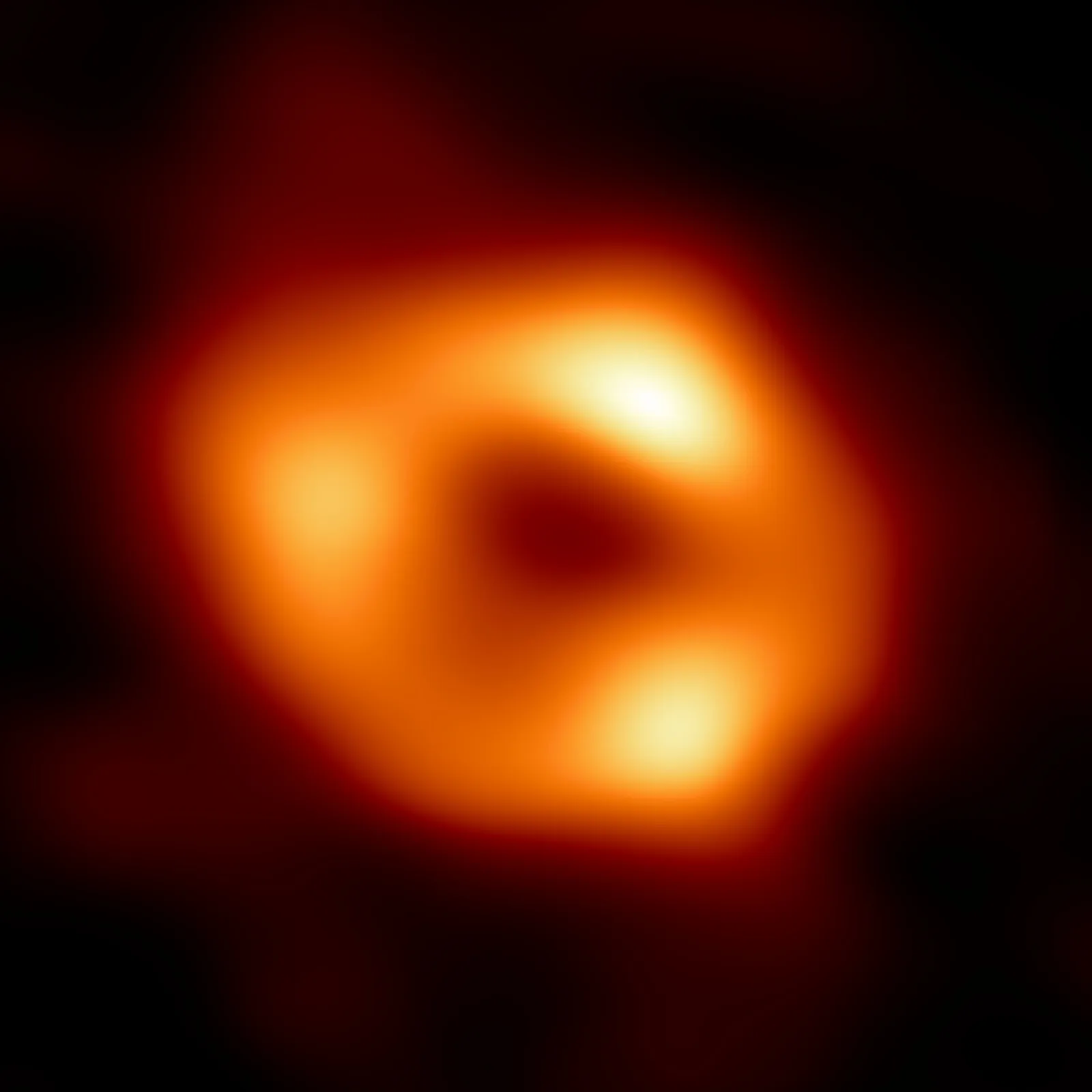 The Event Horizon Telescope image of Sagittarius A*, a bright orange ring of glowing gas surrounding a dark central shadow.