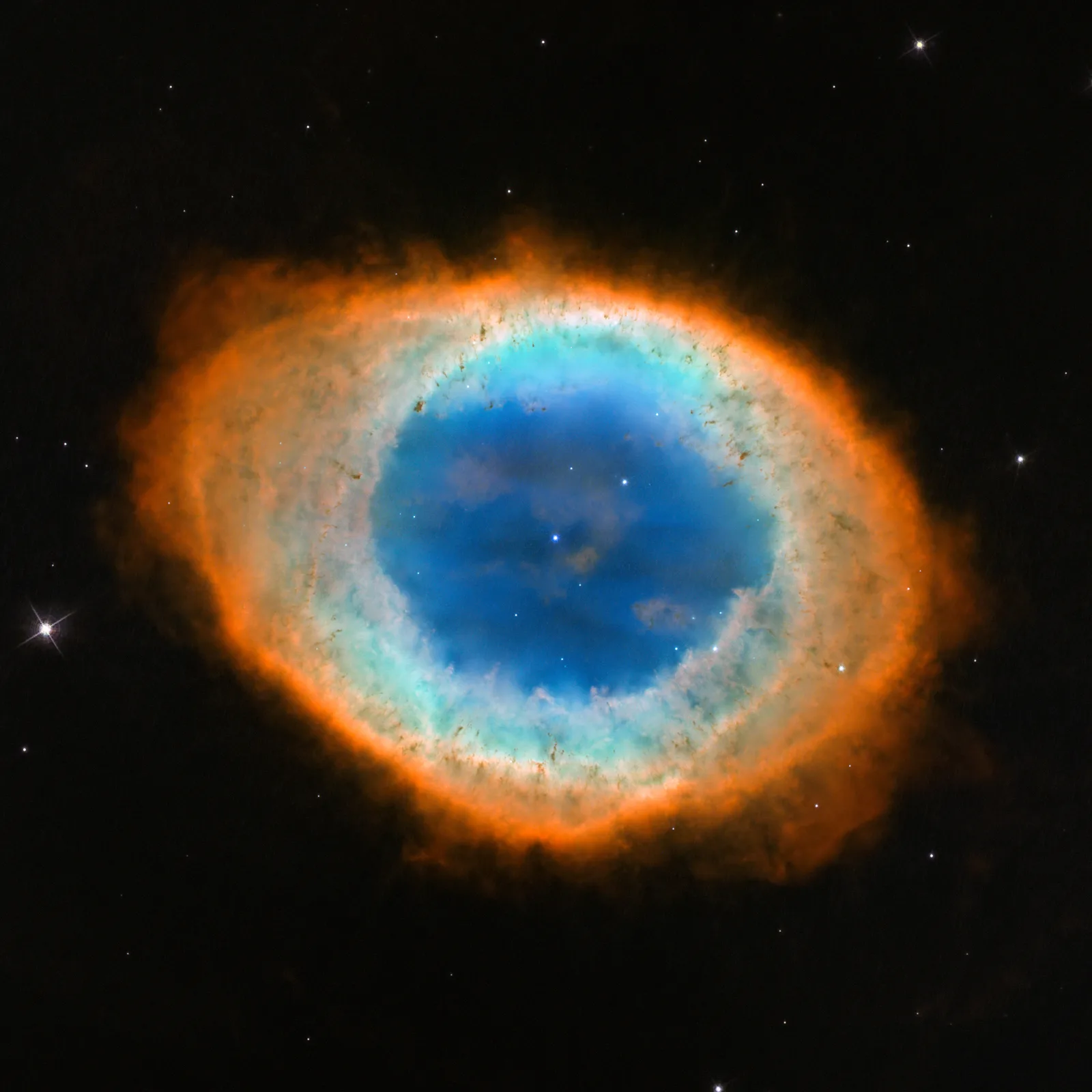 A glowing planetary nebula with a small hot white dwarf star at its center, the ejected outer layers of a dying Sun-like star